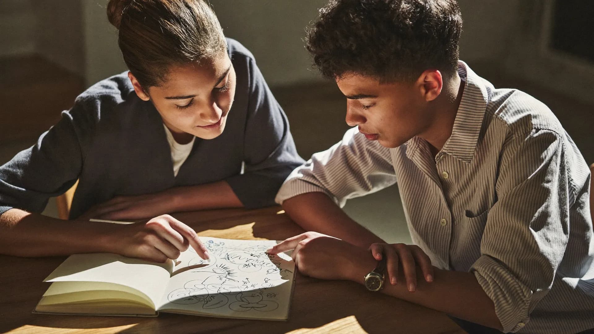 Mentor and student reviewing a plan sketched in a notebook together