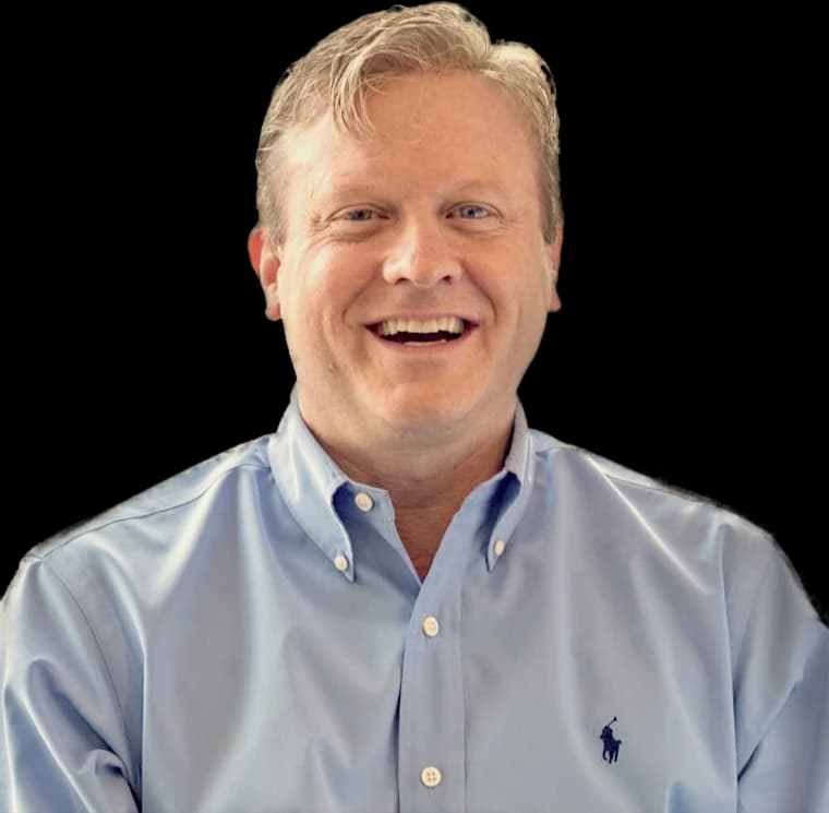 Michael McCarthy, sorrindo, de camisa azul